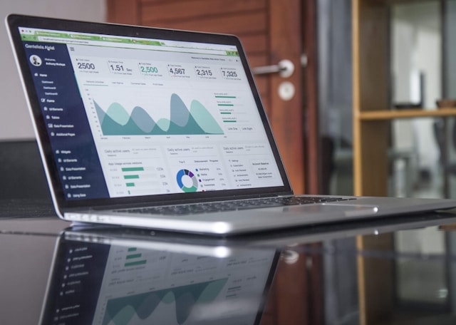 laptop on desk with graphs on screen